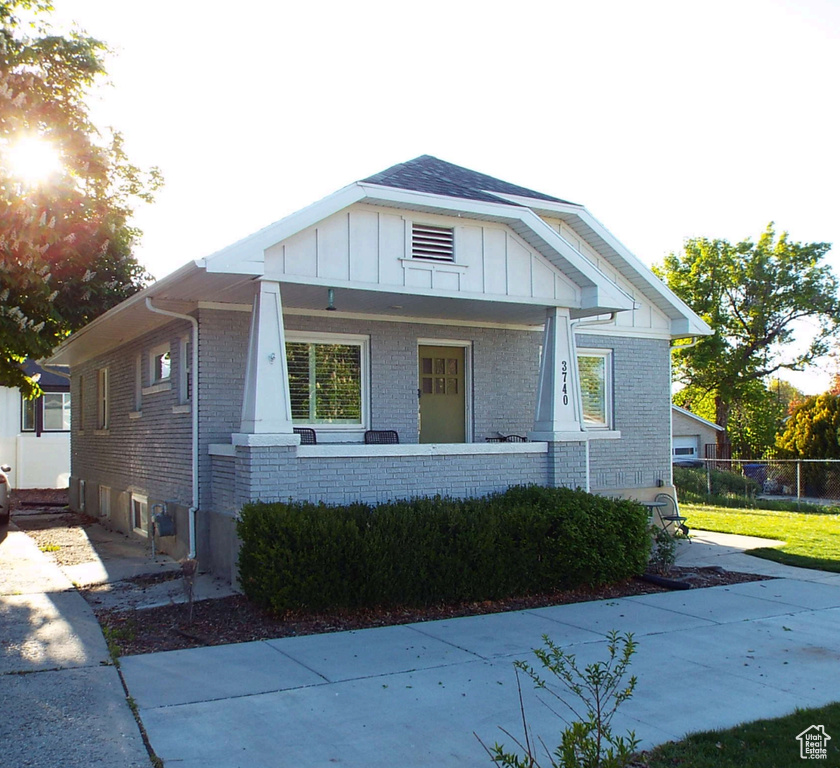 View of front of house featuring brick siding, board and batten siding, and a porch