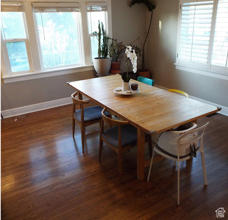 Dining space with baseboards and dark wood-style flooring