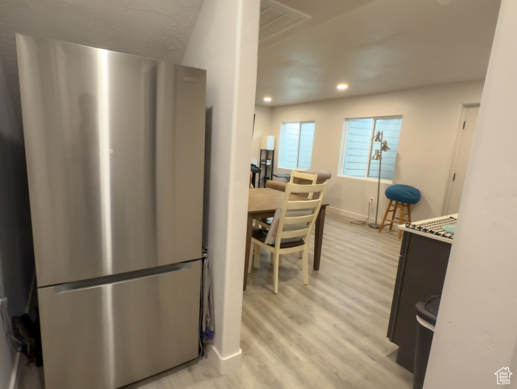 Kitchen featuring freestanding refrigerator, light wood-style flooring, and recessed lighting
