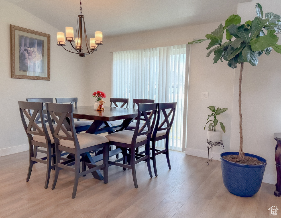 Dining space with light wood finished floors and a chandelier