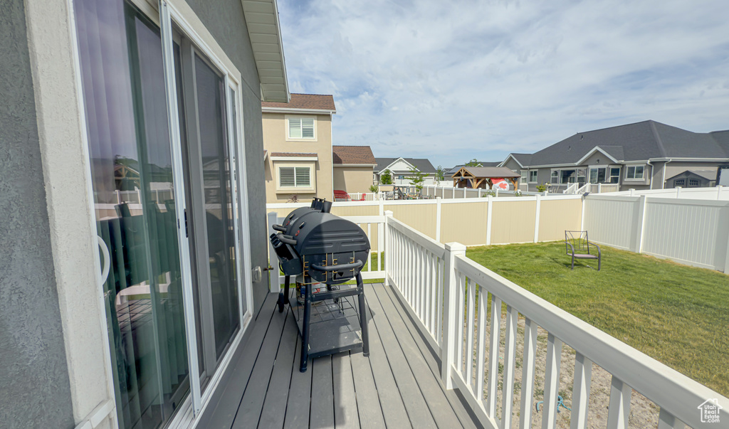 Wooden deck with a residential view, a grill, and a fenced backyard