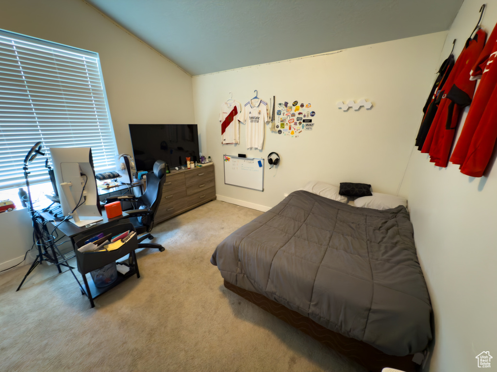 Bedroom featuring carpet floors, vaulted ceiling, and an office area