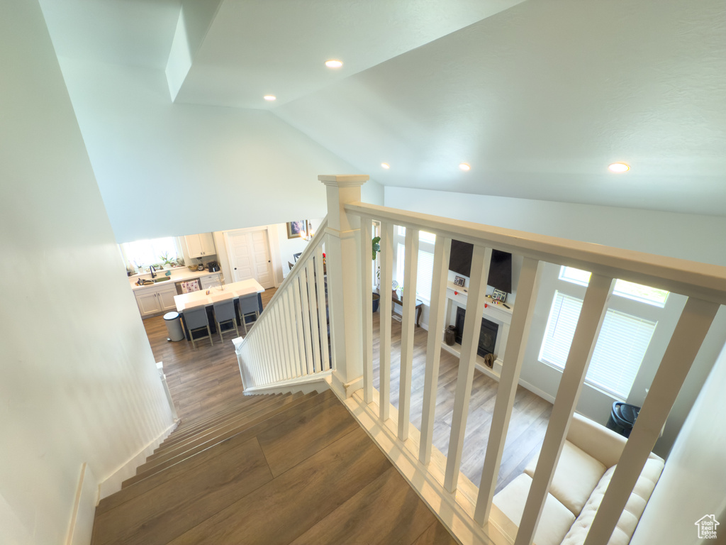 Stairway featuring vaulted ceiling, recessed lighting, and wood finished floors