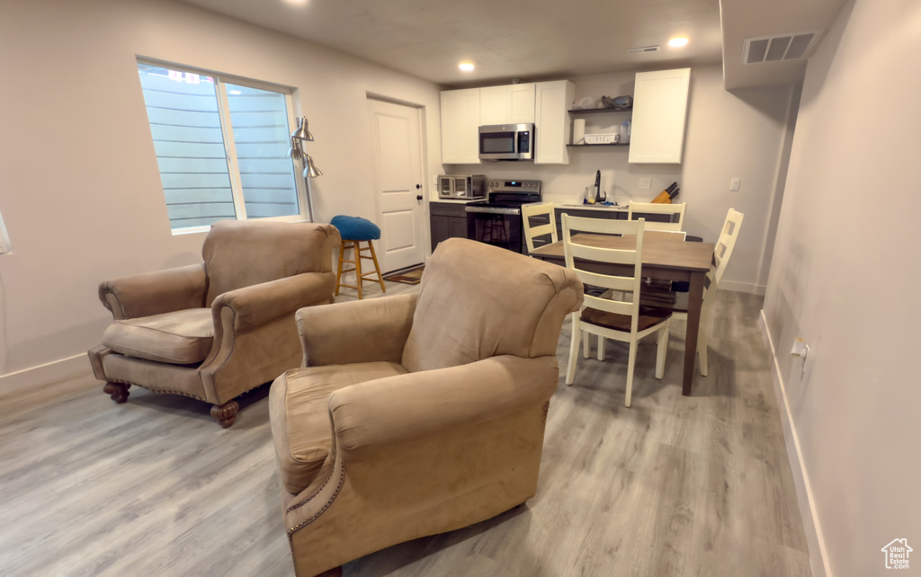 Living room with light wood finished floors and recessed lighting