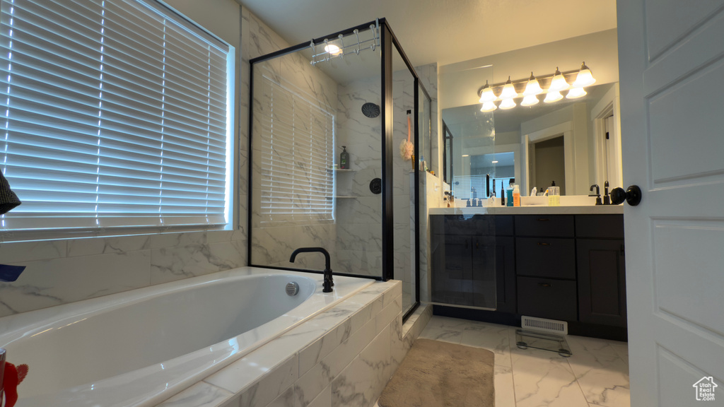 Bathroom featuring a garden tub, marble look tiles, a stall shower, and vanity
