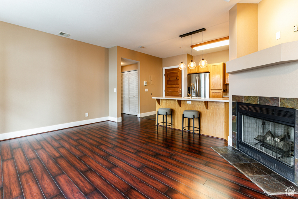 Unfurnished living room with dark wood-style floors and a fireplace