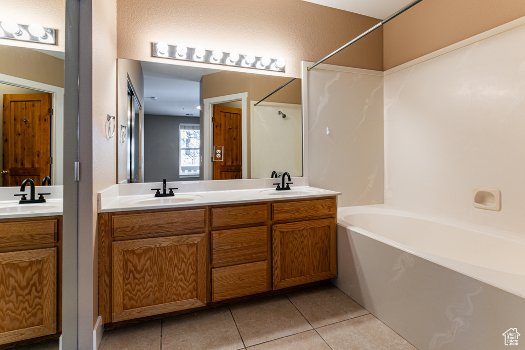 Full bathroom featuring tile patterned floors, double vanity, and tub / shower combination