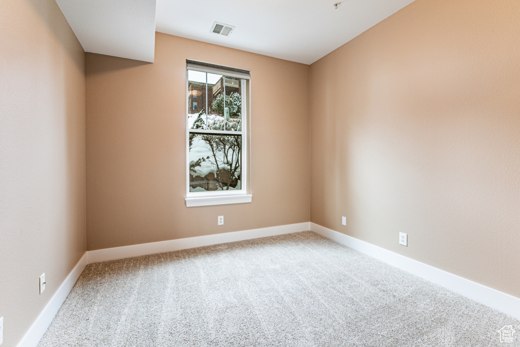 Spare room featuring carpet floors and baseboards
