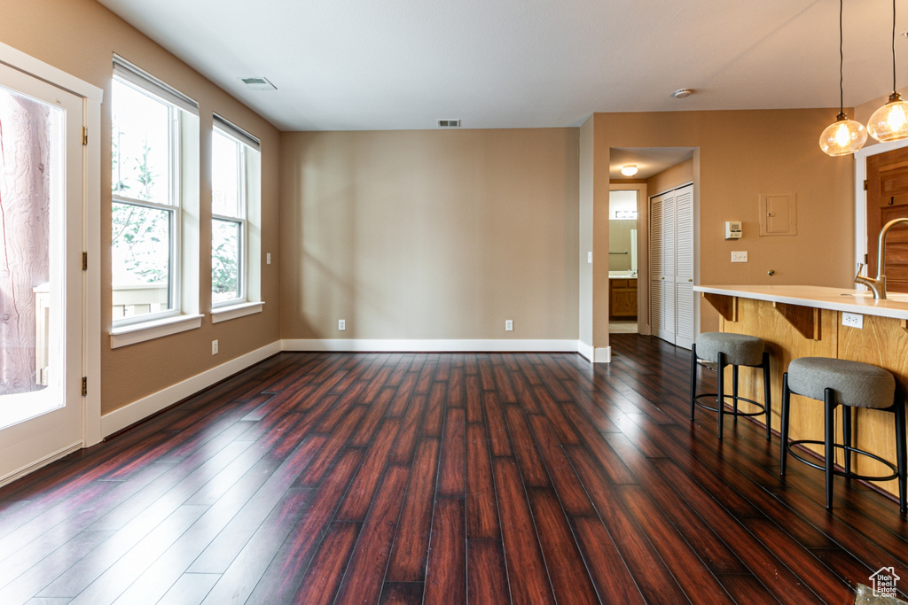 Unfurnished living room with dark wood-style floors and baseboards