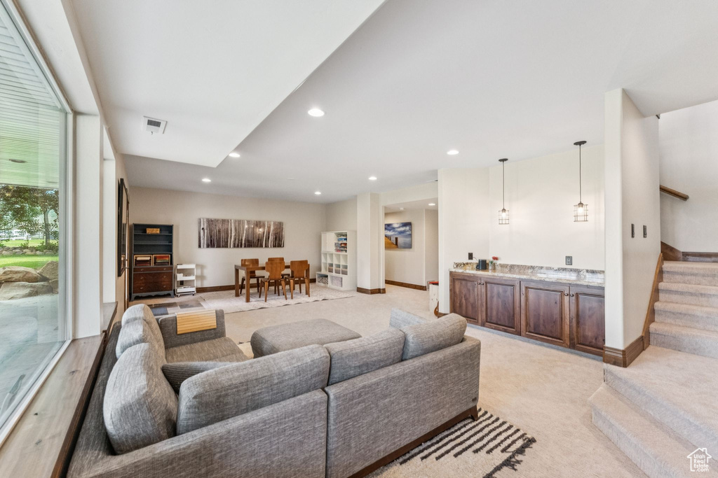 Living area with stairway, light colored carpet, and recessed lighting