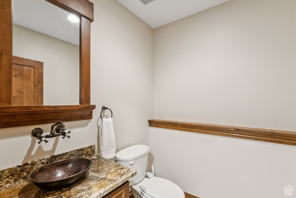 Half bathroom featuring toilet and vanity