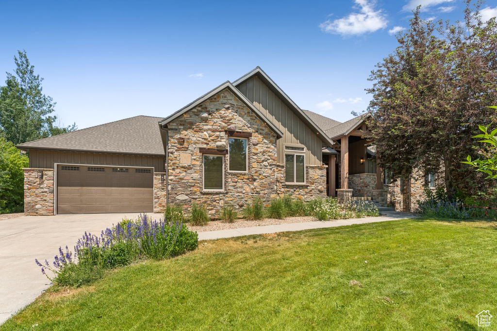 Craftsman inspired home with board and batten siding, stone siding, and driveway