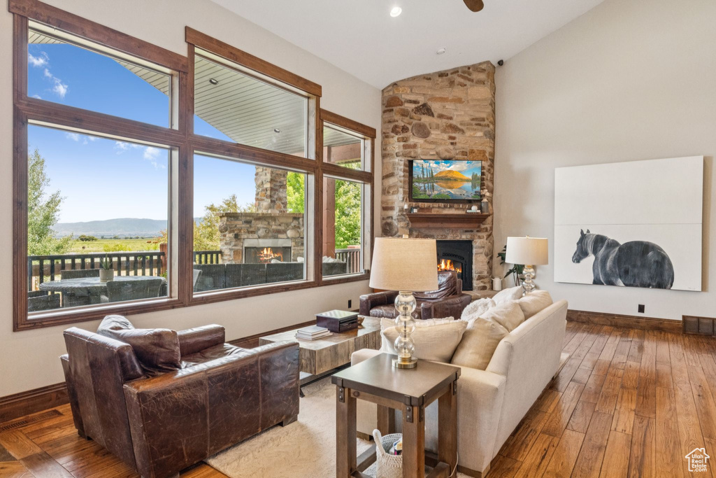 Living room featuring a large fireplace, hardwood / wood-style flooring, a mountain view, and high vaulted ceiling