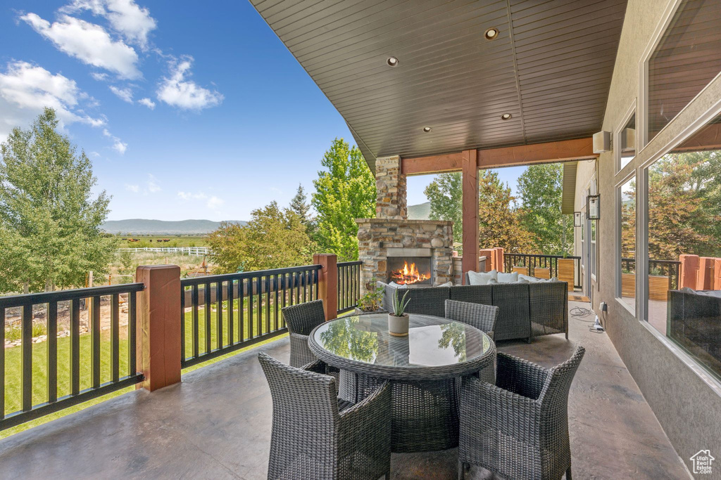 View of patio / terrace with an outdoor living space with a fireplace, a mountain view, and outdoor dining area
