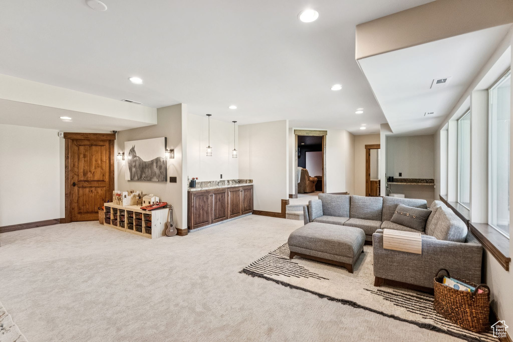 Living area featuring wet bar, recessed lighting, and light colored carpet