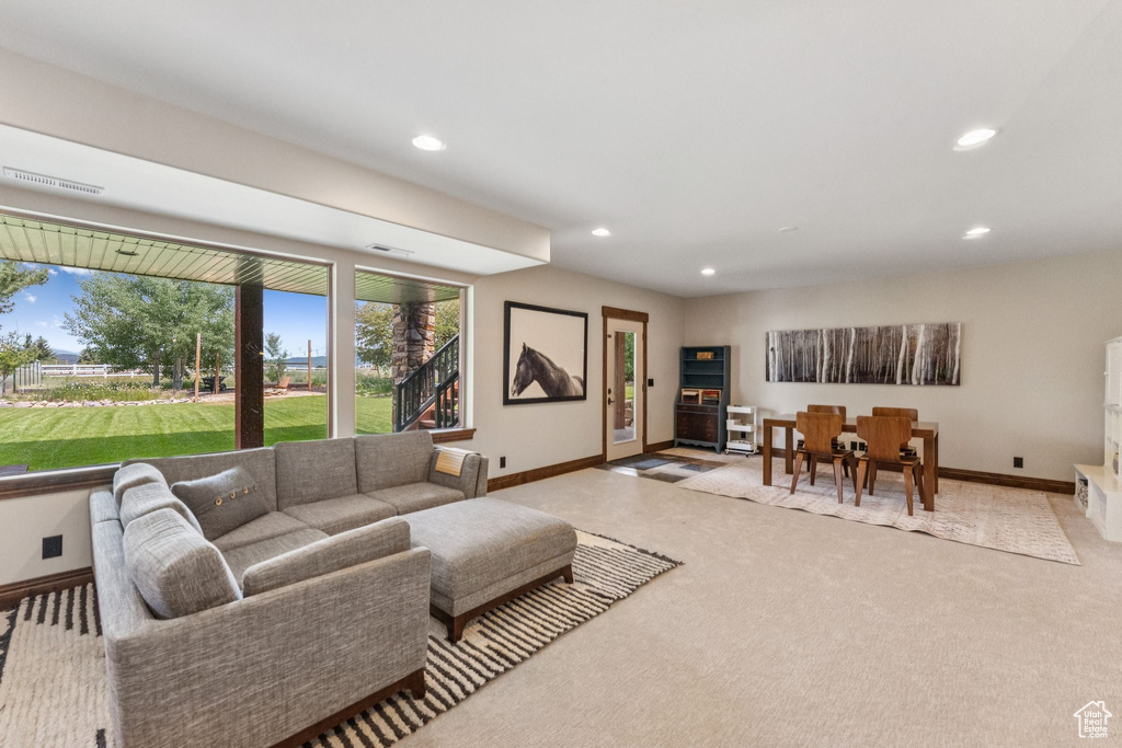 Carpeted living room featuring recessed lighting and baseboards