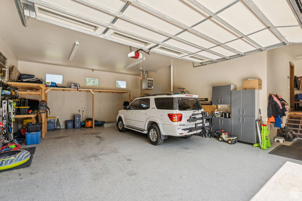 Garage featuring a garage door opener and a heating unit
