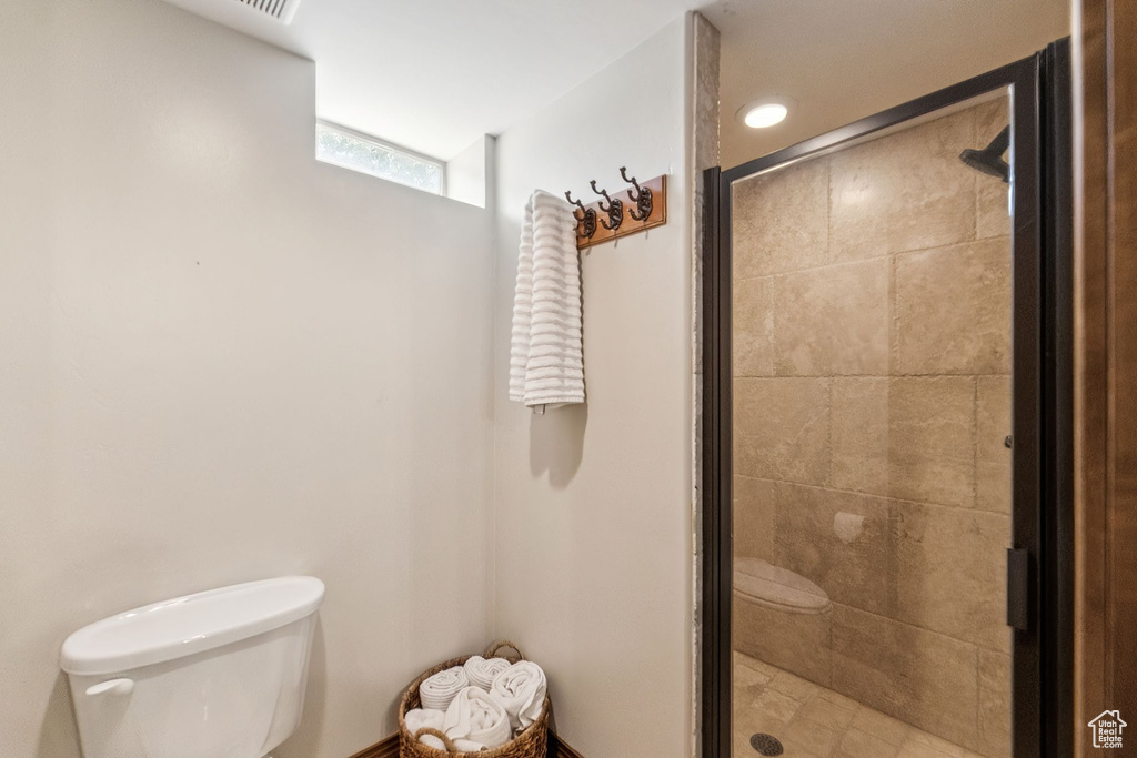 Full bathroom featuring toilet and a shower stall