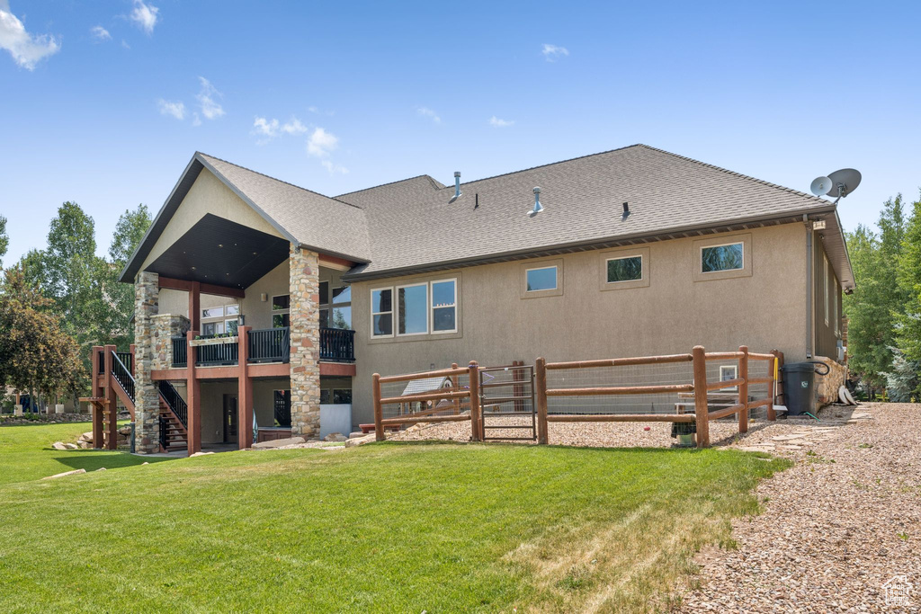 Back of house with stairs, a deck, a shingled roof, and stucco siding