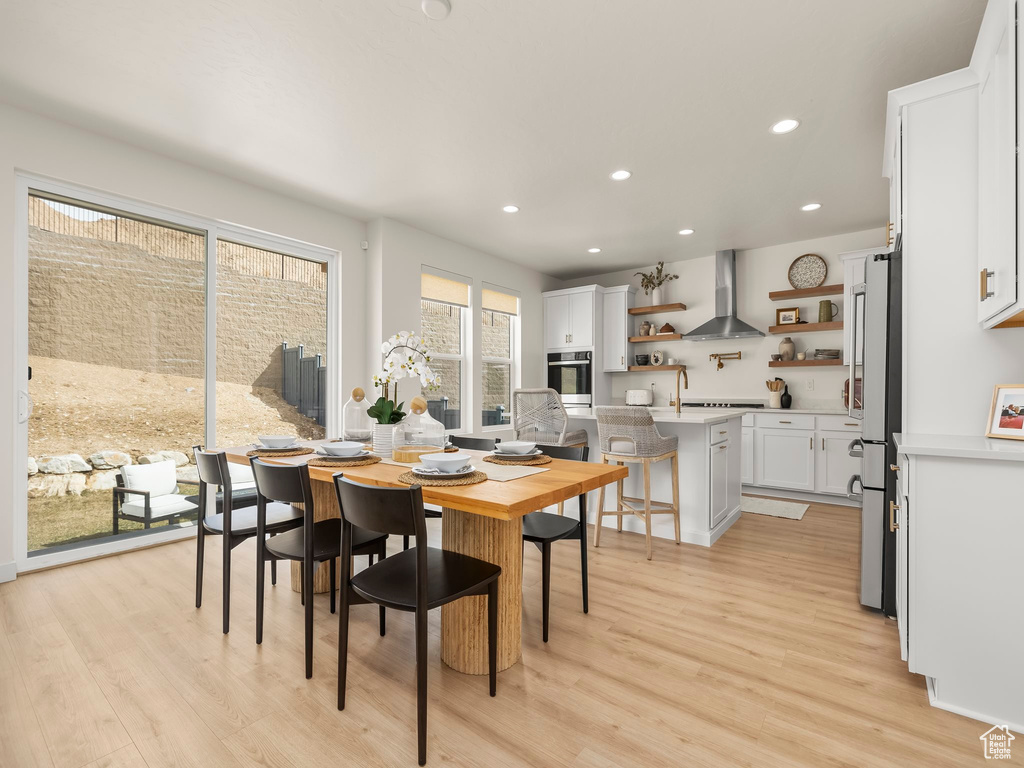 Dining space with light wood-style floors and recessed lighting