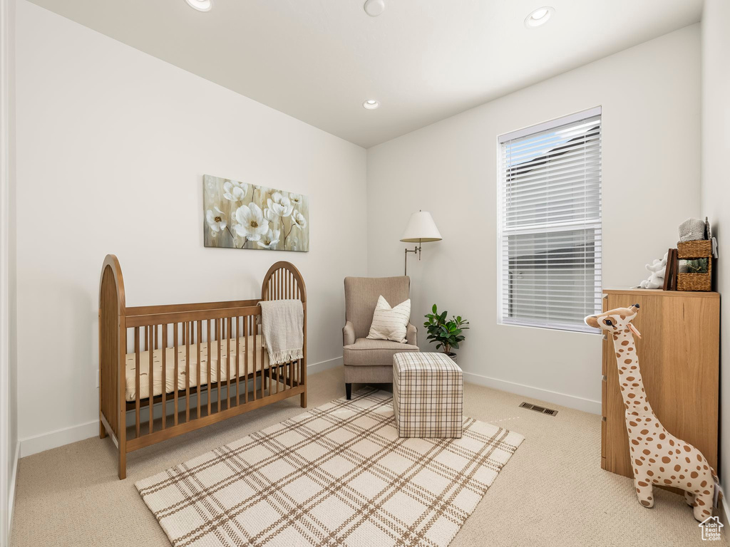 Bedroom featuring carpet floors, recessed lighting, and a crib