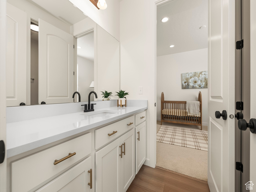 Bathroom with vanity, wood finished floors, and recessed lighting