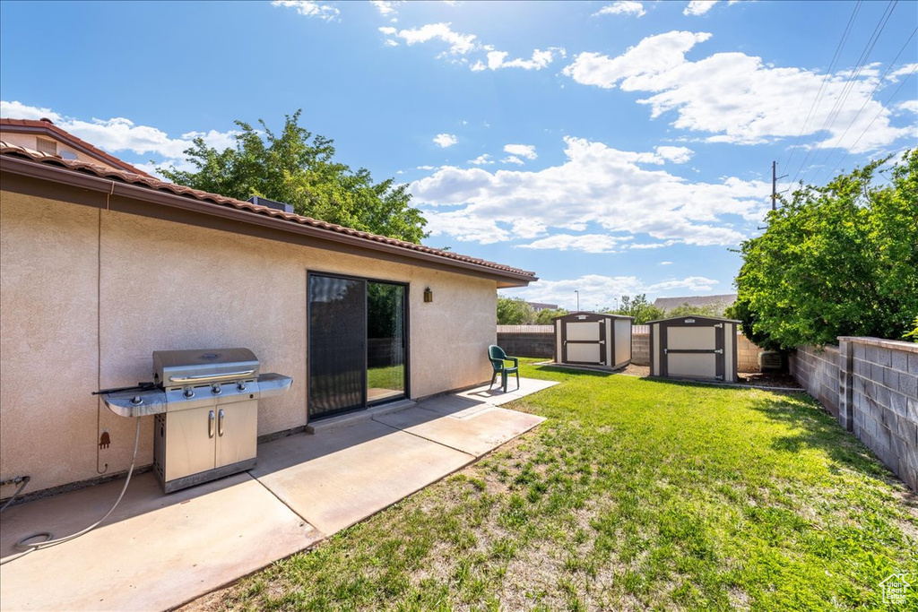 Fenced backyard featuring a shed and a patio area