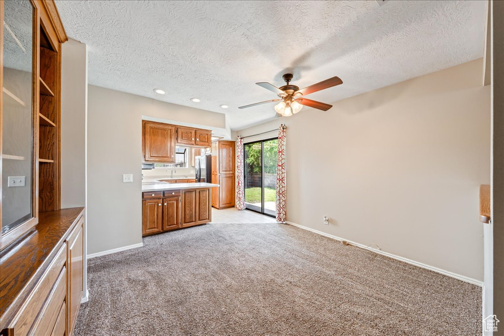 Unfurnished living room with ceiling fan, light colored carpet, a textured ceiling, and recessed lighting