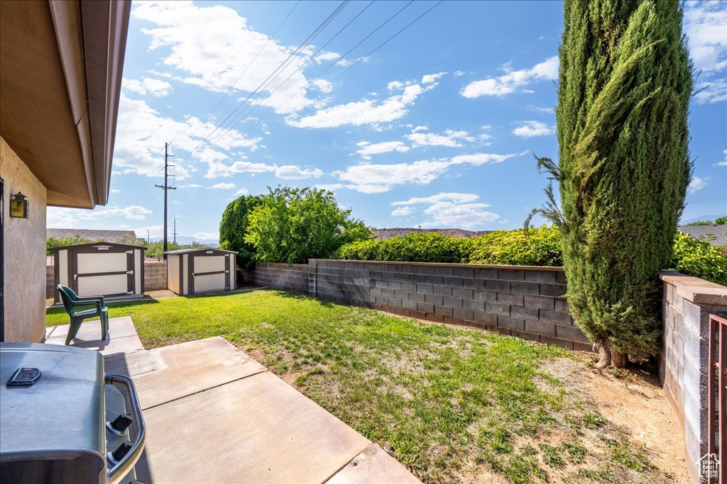Fenced backyard with a storage shed and a patio area