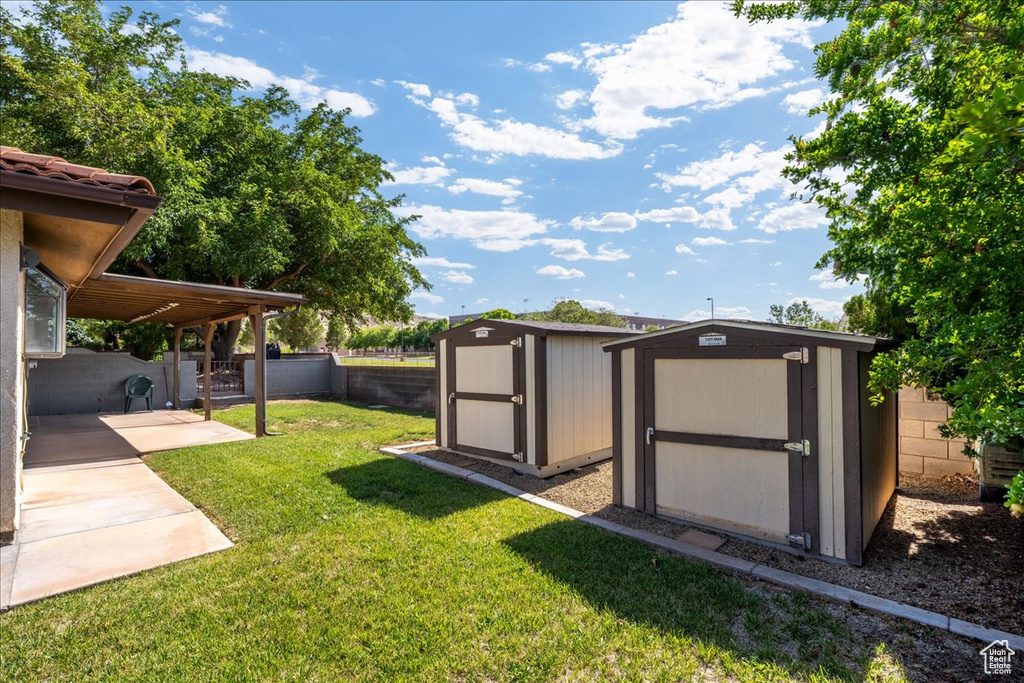Fenced backyard featuring a storage shed and a patio