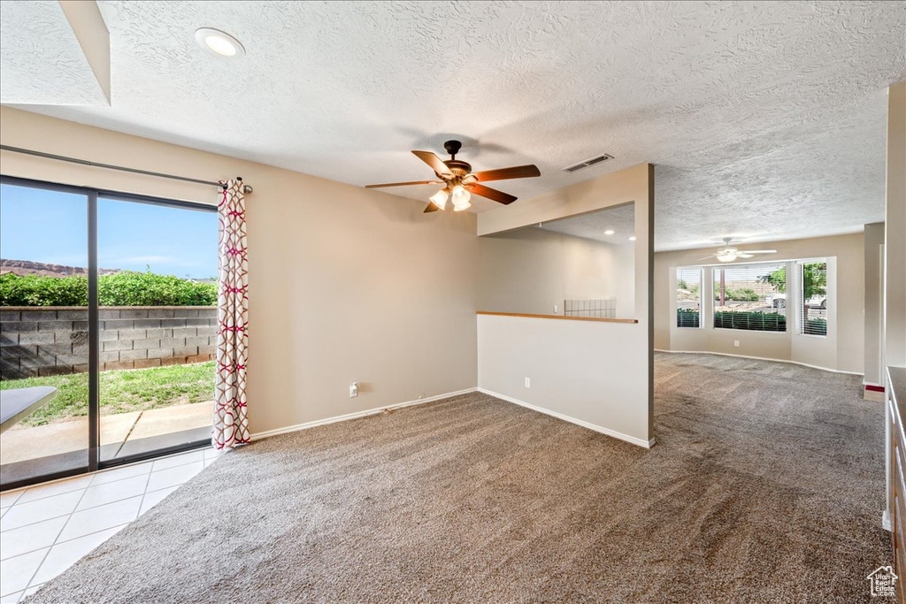 Empty room with a ceiling fan, carpet flooring, a textured ceiling, and recessed lighting