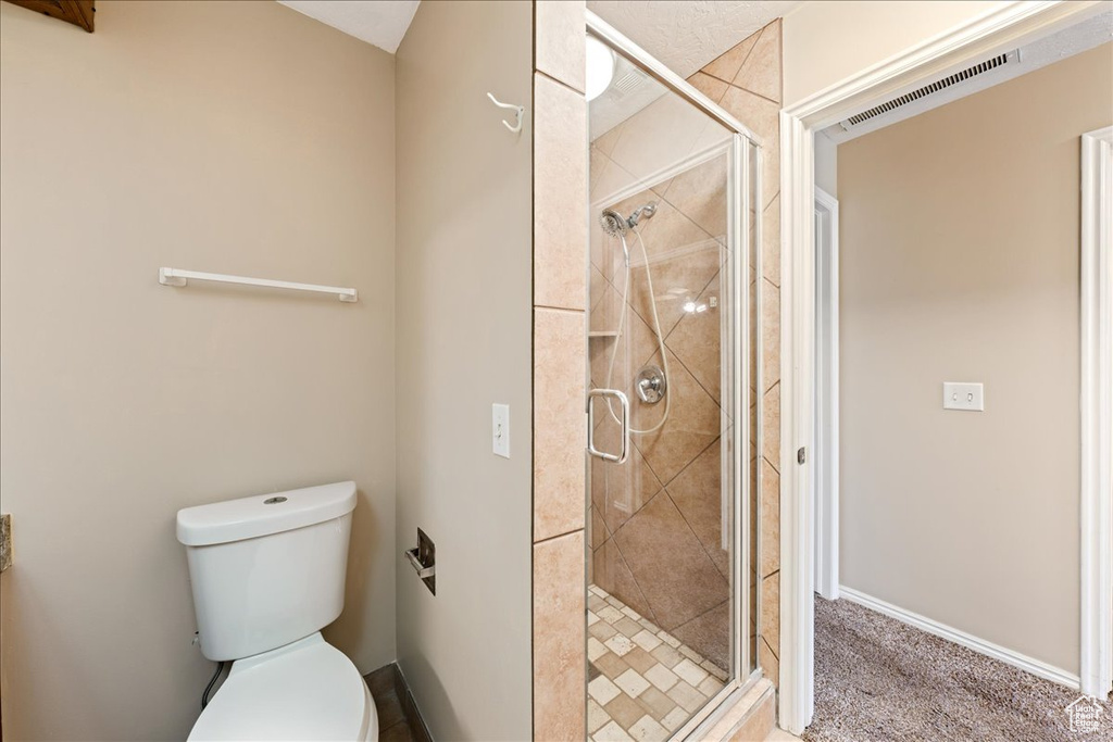 Full bathroom with toilet and a shower stall
