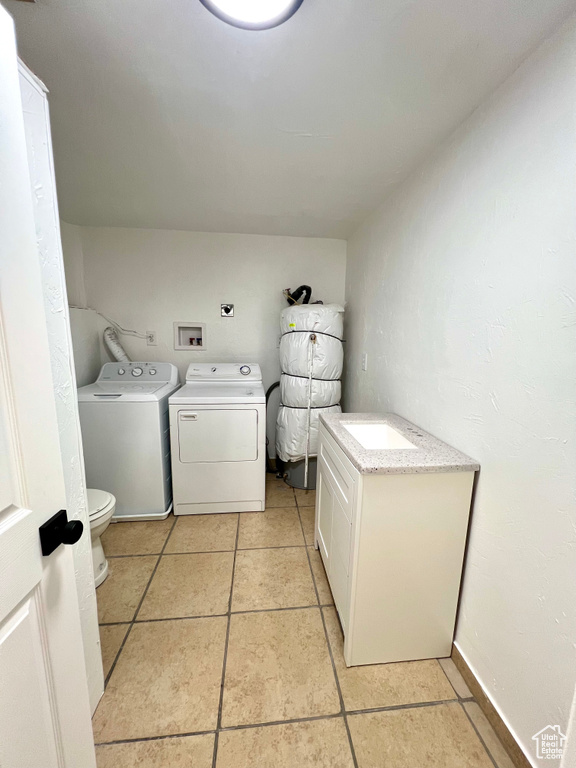 Washroom featuring washer and clothes dryer and light tile patterned floors