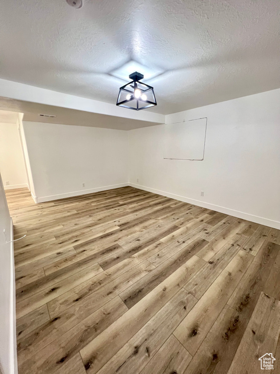 Bonus room featuring light wood-type flooring and a textured ceiling