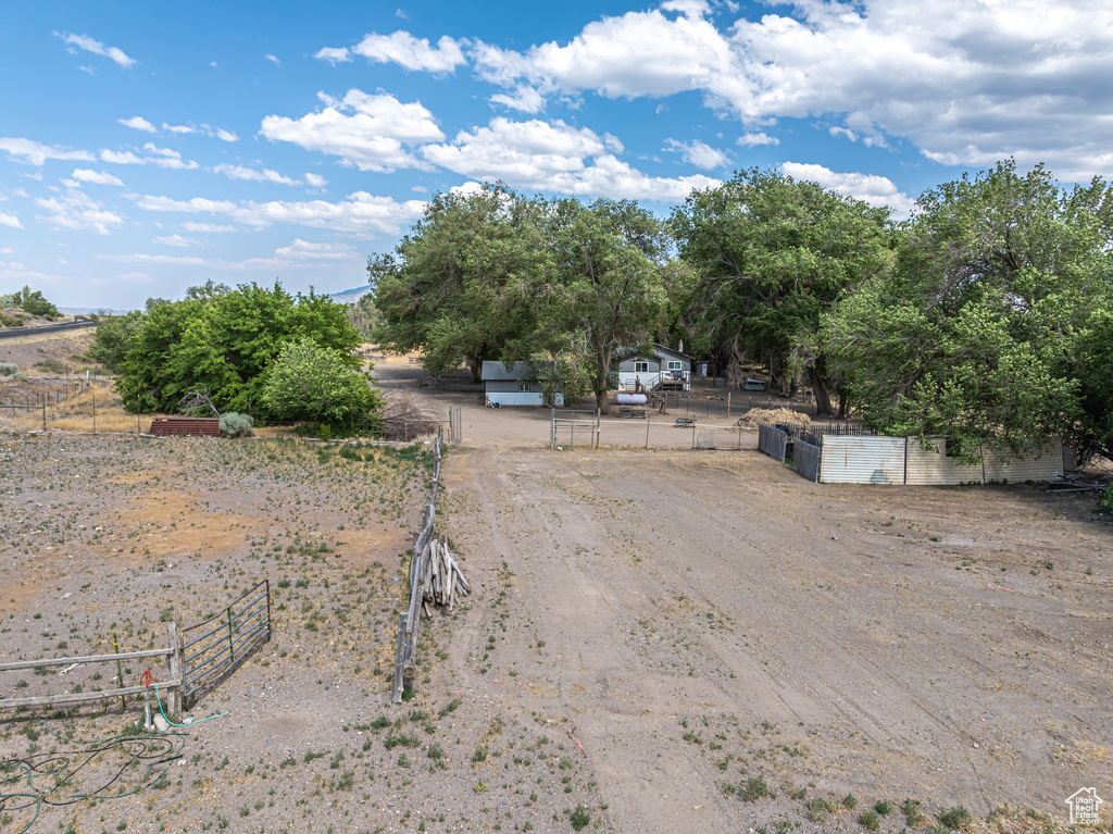 View of dirt / gravel road with a view of rural / pastoral area and a gated entry
