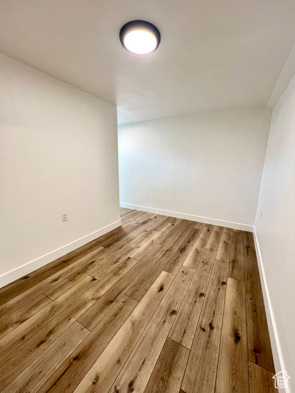 Unfurnished room featuring hardwood / wood-style floors and baseboards