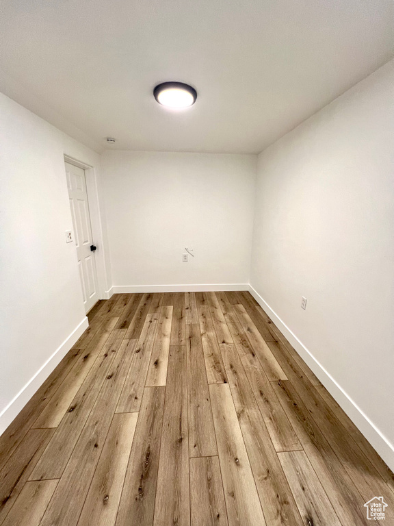 Spare room featuring wood-type flooring and baseboards