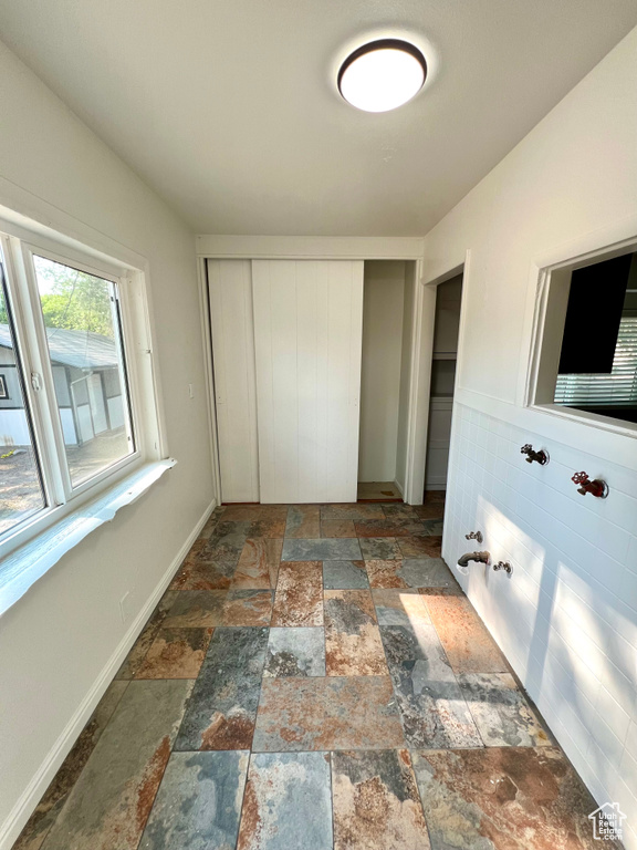 Unfurnished bedroom with stone tile flooring and a closet