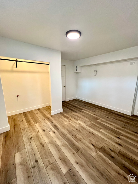 Unfurnished bedroom with hardwood / wood-style flooring and baseboards