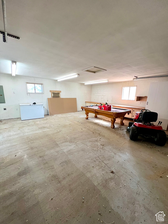 Basement featuring healthy amount of natural light, pool table, and electric panel