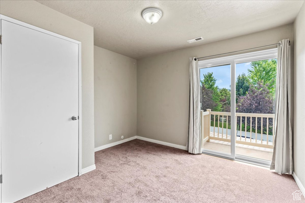 Unfurnished room featuring carpet and a textured ceiling