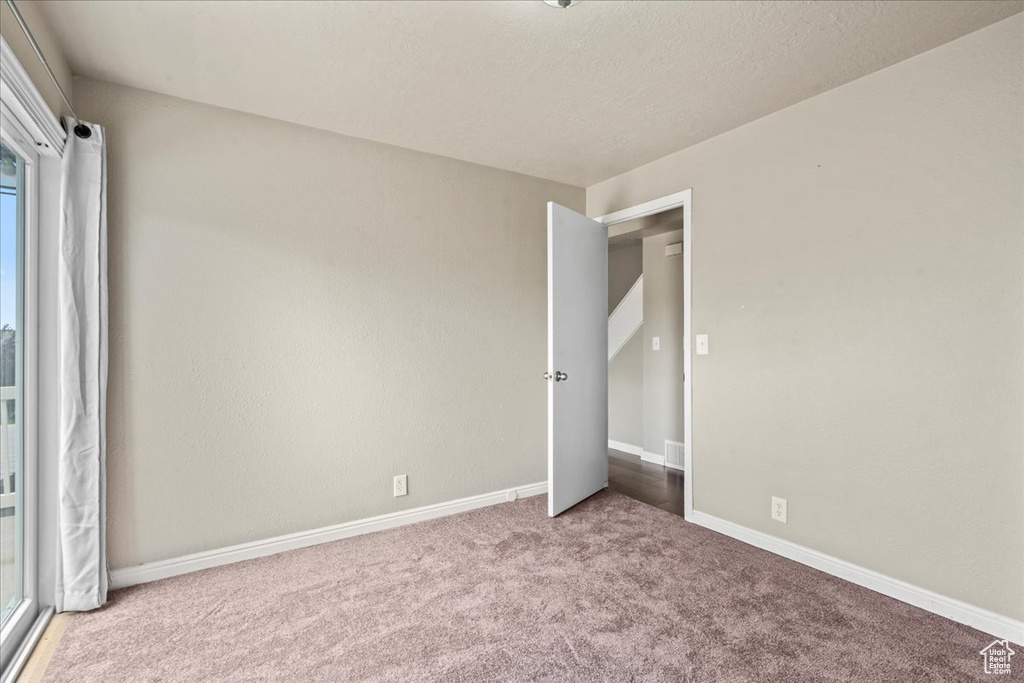 Unfurnished bedroom featuring carpet and multiple windows