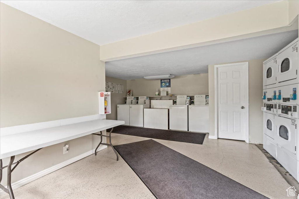 Communal laundry room with stacked washing machine and dryer and washer and dryer