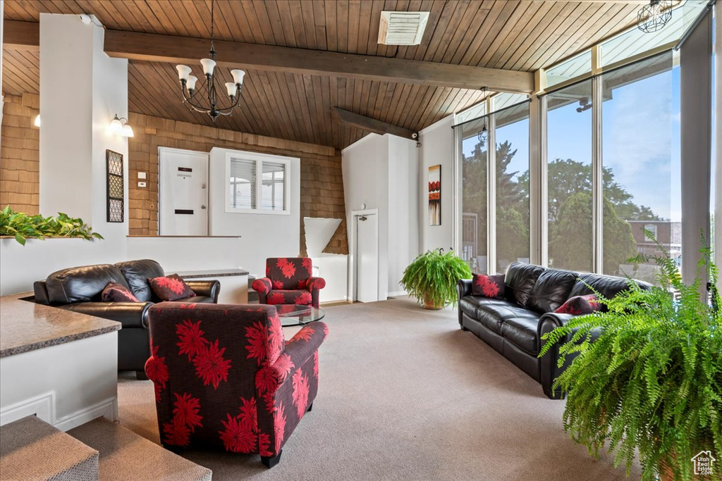 Carpeted living room featuring a chandelier and wood ceiling