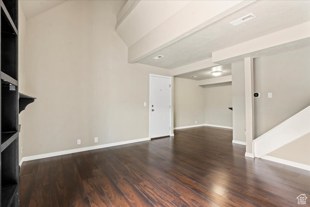 Unfurnished living room featuring wood finished floors and stairs