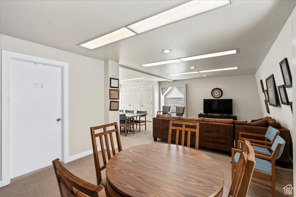 Dining room with light colored carpet and recessed lighting