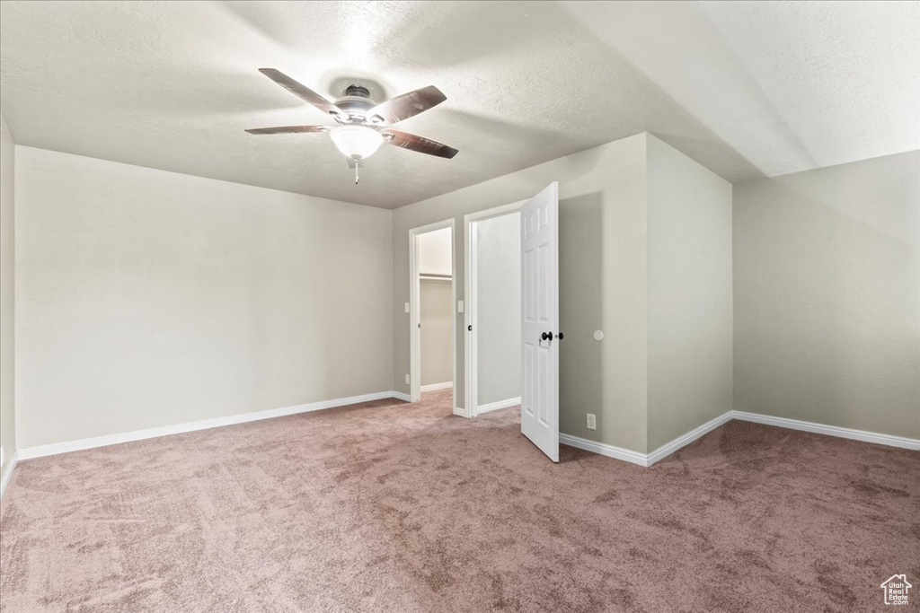 Unfurnished bedroom featuring carpet flooring, a textured ceiling, and a ceiling fan