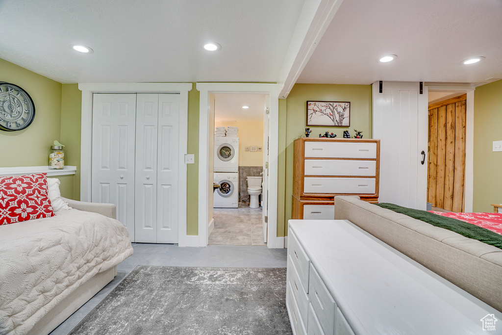 Bedroom featuring stacked washing machine and dryer, recessed lighting, and a closet