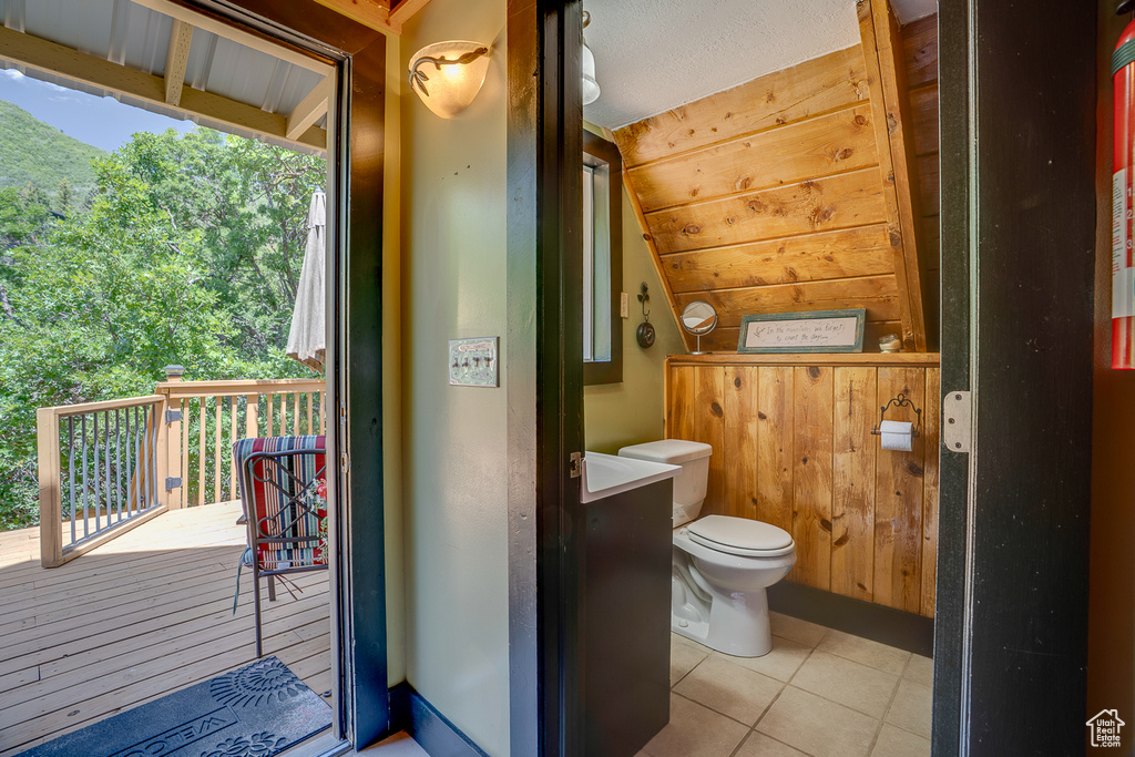 Bathroom featuring tile patterned floors and vaulted ceiling
