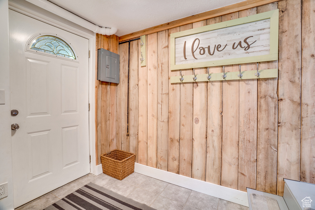 Mudroom featuring wood walls and electric panel